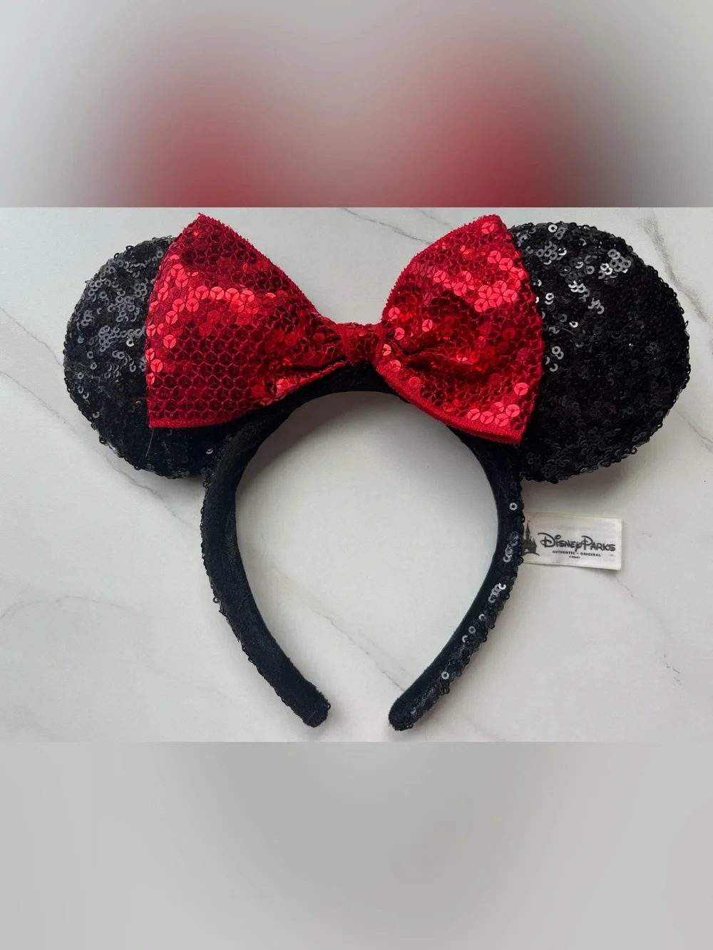 Disney Parks Authentic White Label, black sequin ears with a read sequin bow.